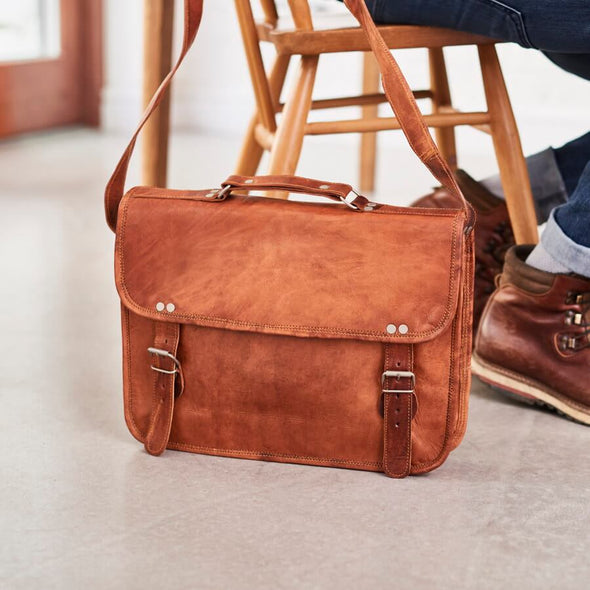Leather laptop bag with handle in tan set on floor