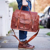 Man holing extra large weekend travel bag with gold initials embossed