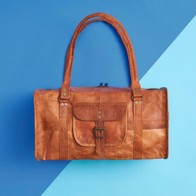 Small leather duffel bag with handles and strap
